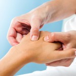 Macro close up of Therapist doing massage on female hand.Osteopath applying pressure on hand.